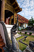 Chiang Mai - The Wat Phra Singh temple. The ubosot (ordination hall). The guardians of the stairs are shaped as a Naga coming out from the mouth of a Makkara. 